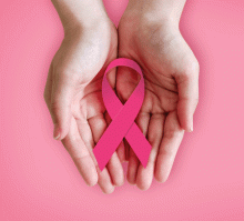 woman holding pink breast cancer ribbon in her hands