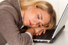 woman exhausted at her laptop