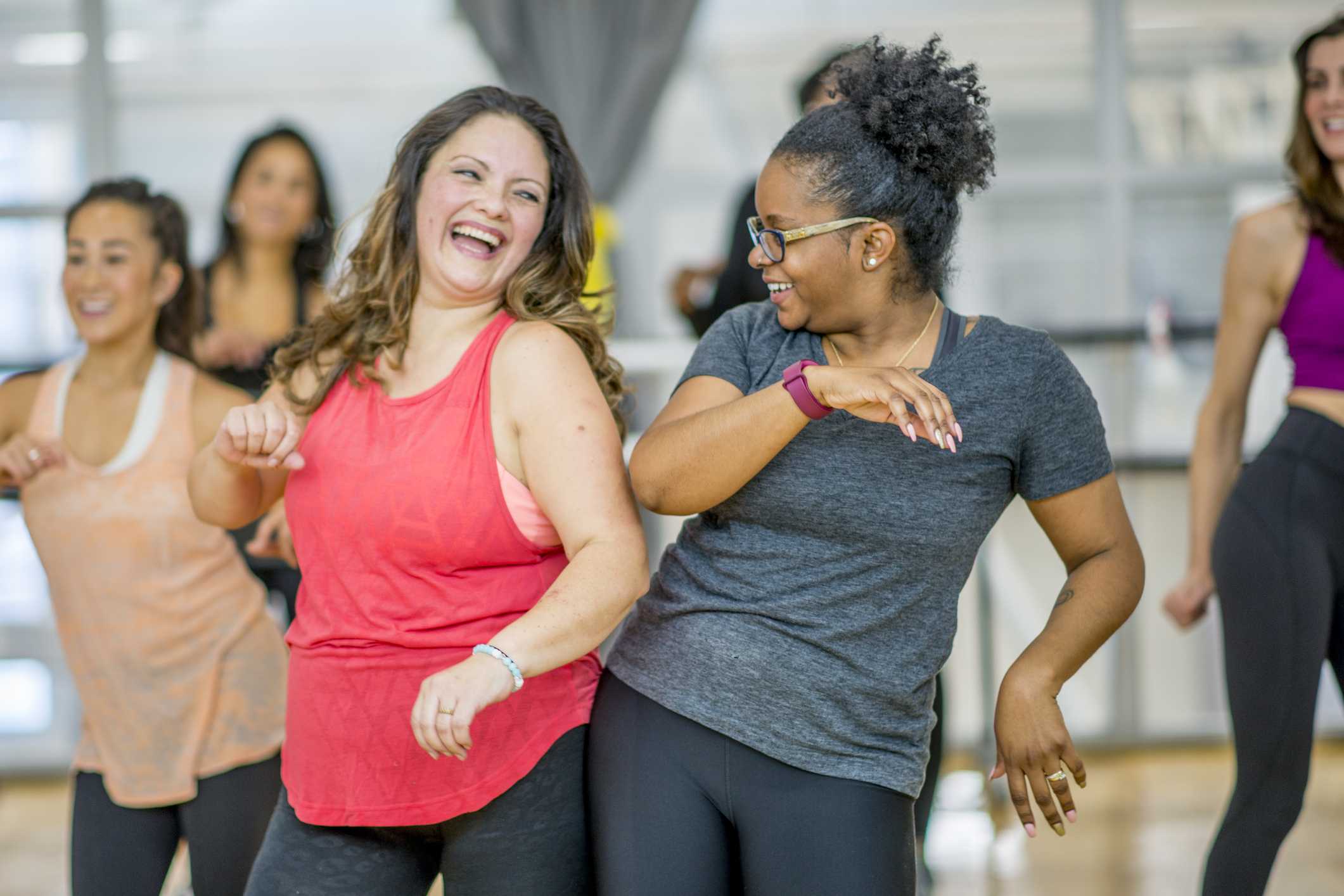 Two woman dancing in an exercise class to reduce their risk of CAD