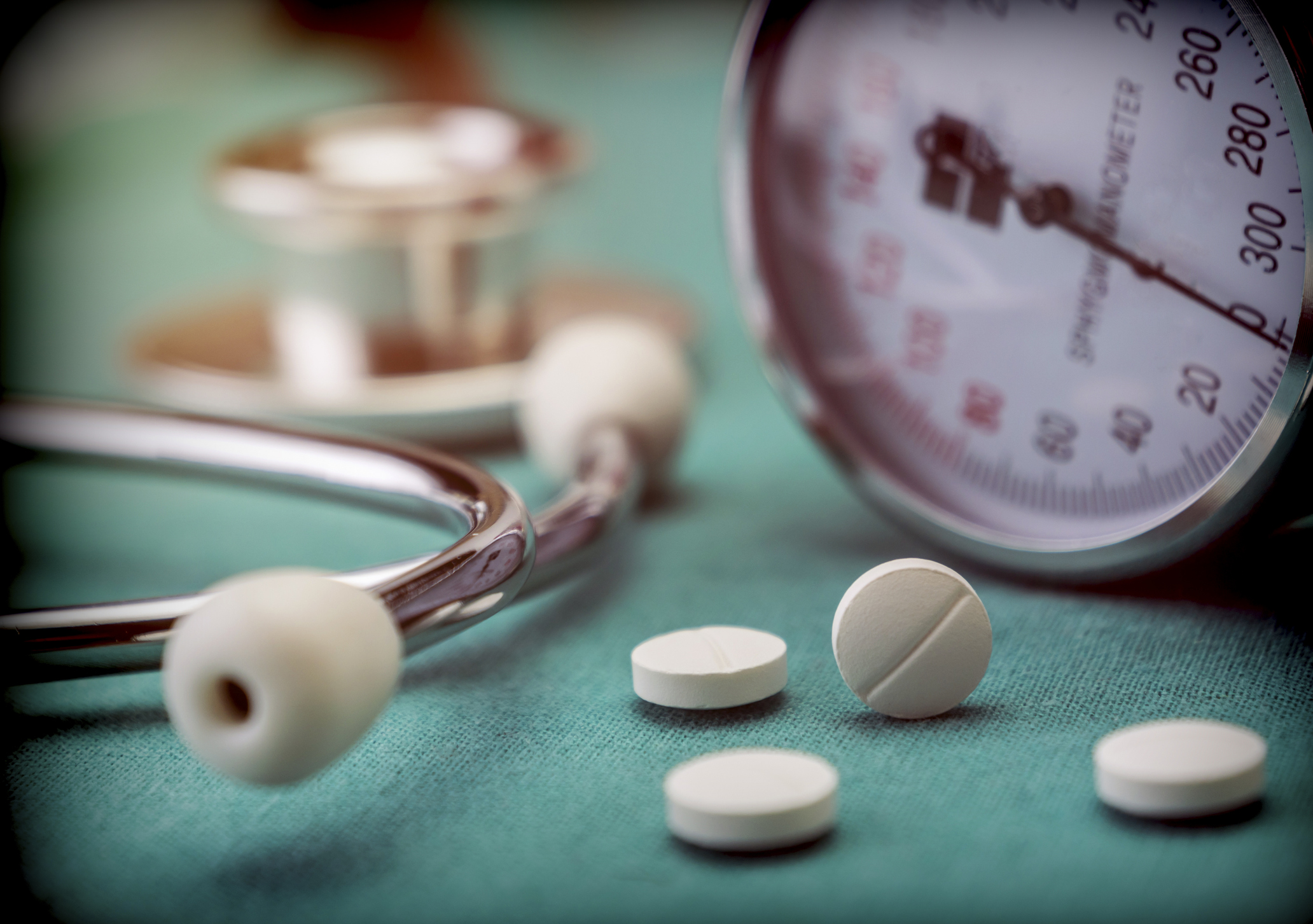 White pad next to a manometer to measure blood pressure and a stethoscope in a hospital, conceptual image