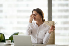 Fatigued businesswoman taking off glasses tired of computer work