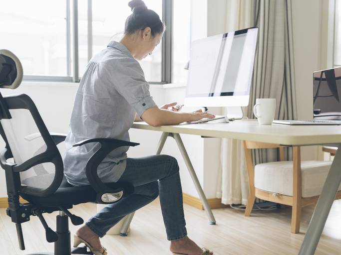 woman sitting at desk with poor posture