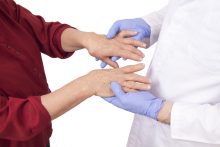 Woman holding her hands with a doctor to talk about her pain symptoms